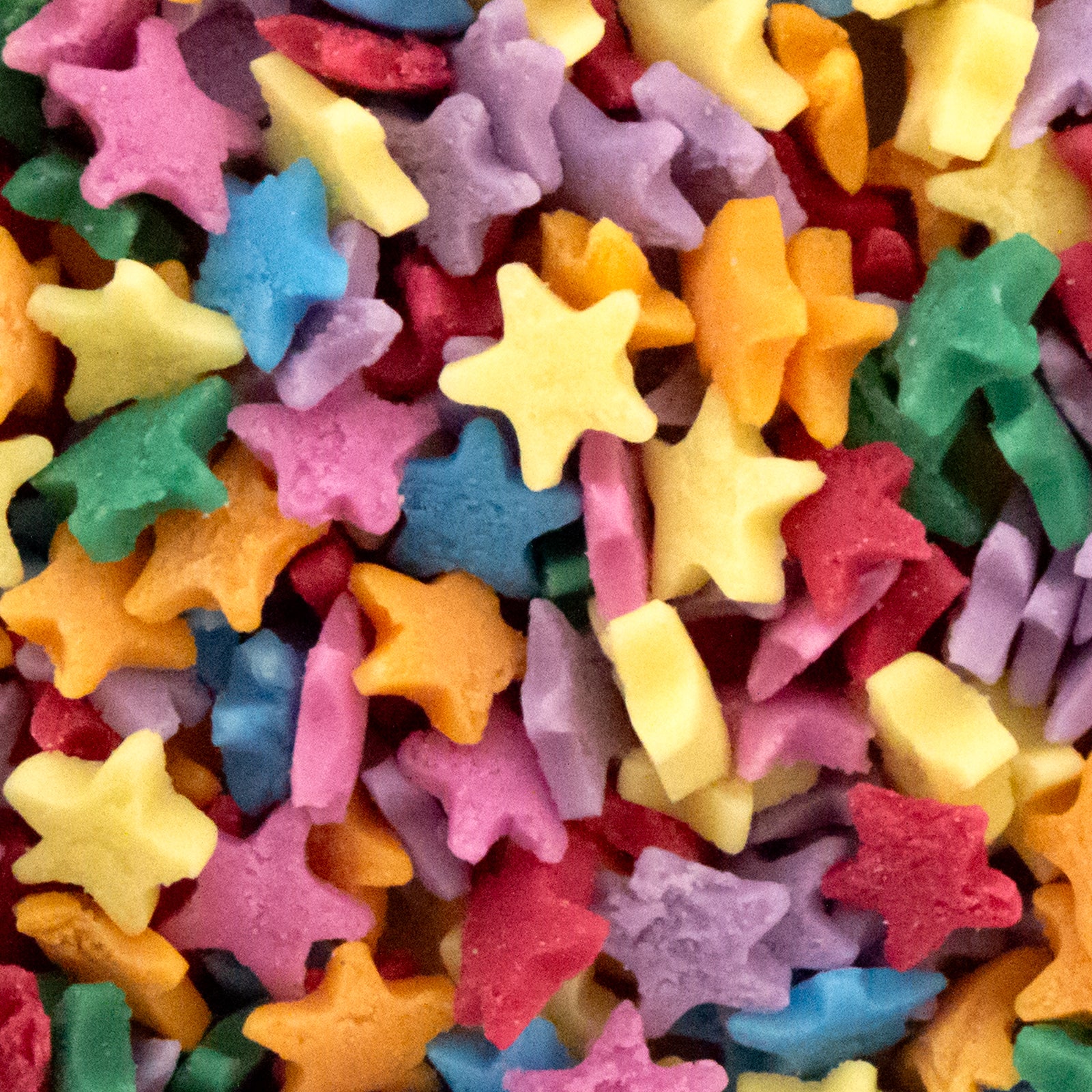 A close-up pile of small star-shaped sugar sprinkles in many bright colours including yellow, pink, blue, green, orange, and purple.
