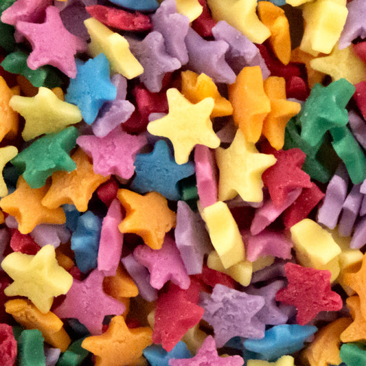 A close-up pile of small star-shaped sugar sprinkles in many bright colours including yellow, pink, blue, green, orange, and purple.
